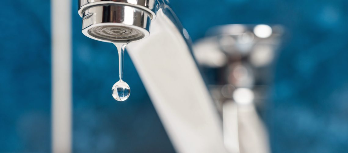 A drop of water drips from a leaky faucet.